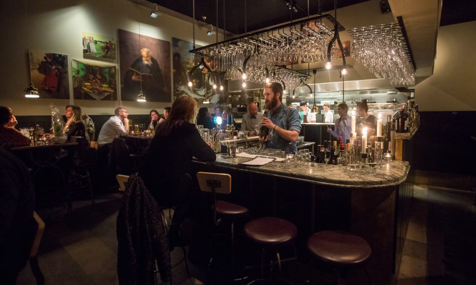 Interiör av restaurang Mr P. Bardisk rakt fram, höga stolar och bord längs väggarna.